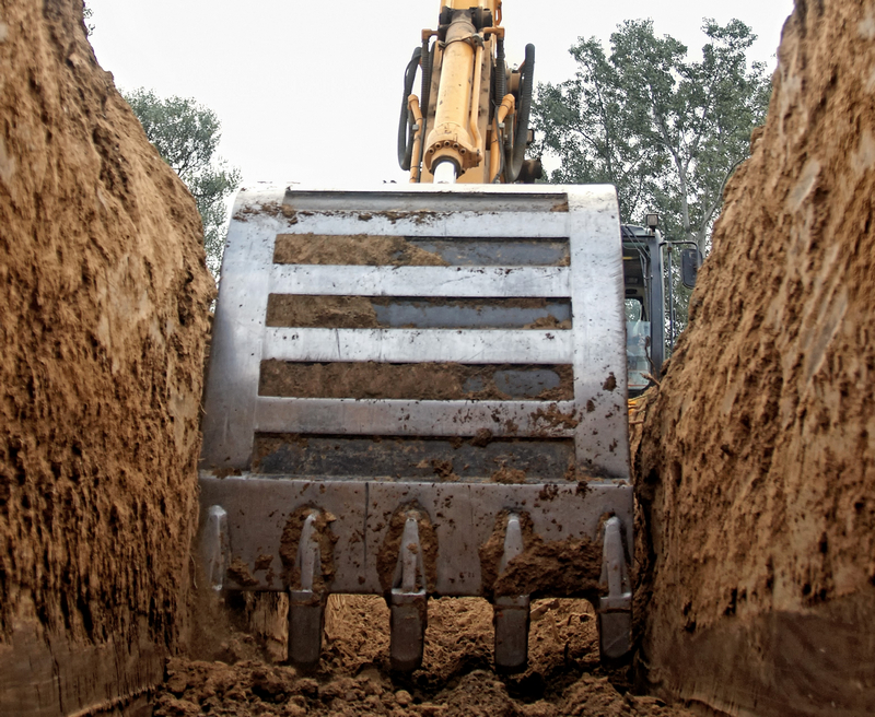 Excavator digging a deep trench